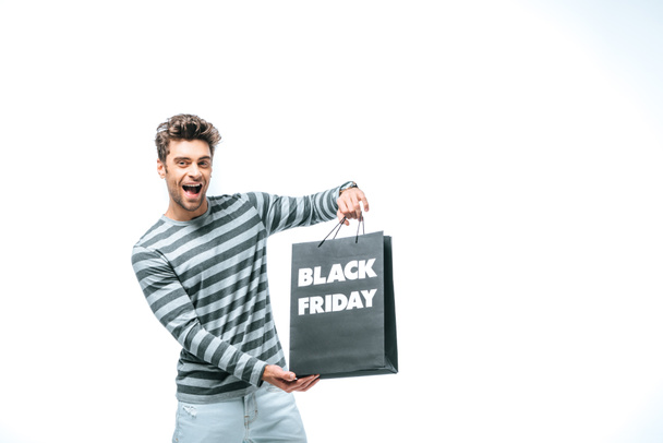 excited man holding shopping bag on black friday, isolated on white - 写真・画像