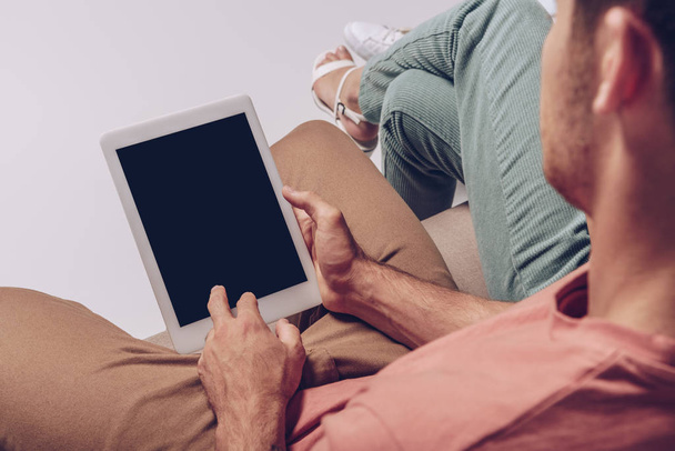 cropped view of couple using digital tablet with blank screen together isolated on grey - Foto, immagini