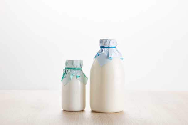 varios productos lácteos orgánicos frescos en botellas sobre mesa de madera aislada en blanco
 - Foto, Imagen