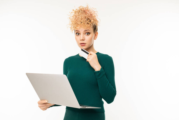 young woman in green dress posing with laptop against white background   - Φωτογραφία, εικόνα