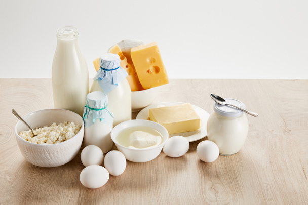 deliciosos productos lácteos orgánicos y huevos en mesa de madera aislada en blanco
 - Foto, imagen