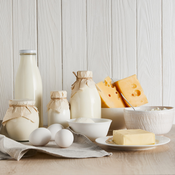 finom friss tejtermékek és tojások fehér fa háttér - Fotó, kép