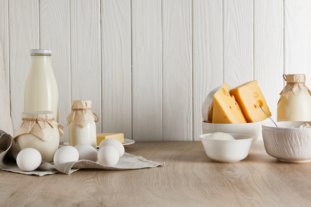 delicious fresh dairy products and eggs on white wooden background - Fotoğraf, Görsel