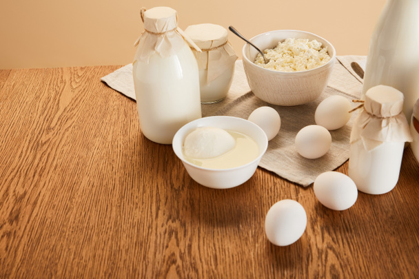 varios productos lácteos orgánicos frescos y huevos en mesa de madera rústica aislada en beige
 - Foto, imagen