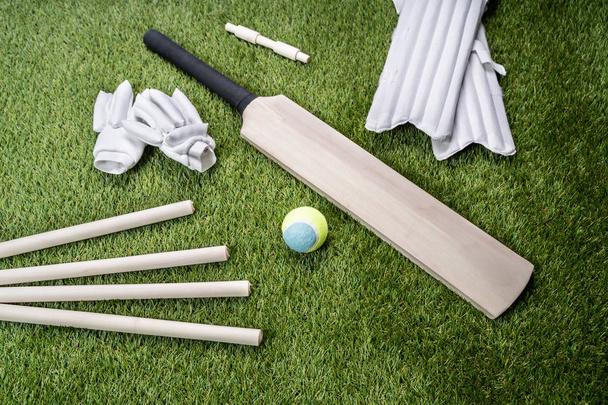 Close-up Of Wooden Cricket Bat And Ball On Turf Grass - Фото, изображение