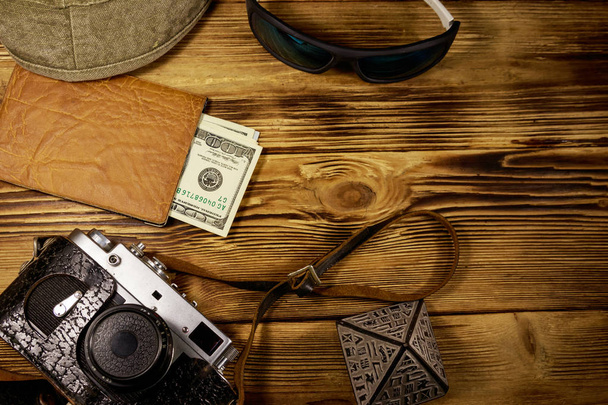 Travel vacation concept. Retro photo camera, hat, sunglasses, souvenir pyramid and passport with money on wooden background. Travel to Egypt. Top view, flat lay - Photo, Image
