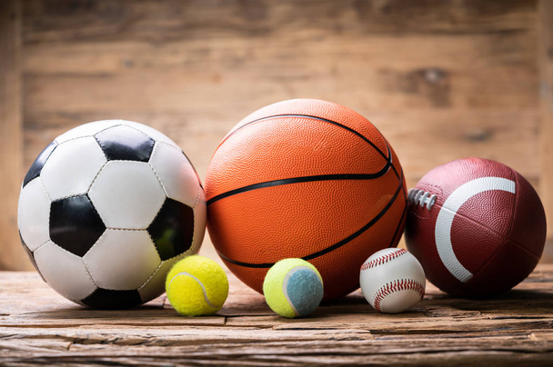 Different Sport Balls Arranged In Row Over Rough Wooden Plank - Foto, Imagen