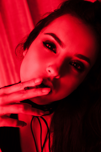 vonzó érzéki nő dohányzás cigaretta piros fényben - Fotó, kép