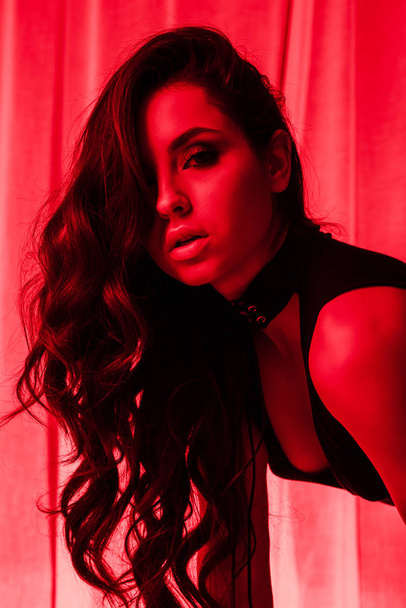 attractive sensual young woman posing in bodysuit in red light - Φωτογραφία, εικόνα