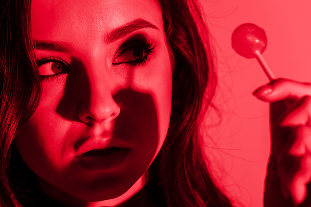 houkutteleva intohimoinen tyttö syö tikkari punaisessa valossa
 - Valokuva, kuva