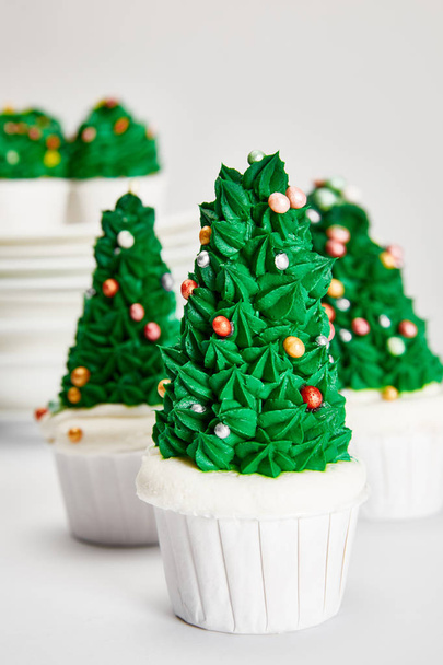 delicious Christmas tree cupcakes on white surface isolated on grey - Foto, imagen
