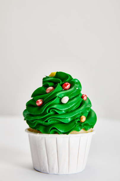 tasty Christmas tree cupcake on white surface isolated on grey - Foto, Imagen