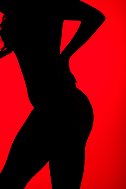 silhouette noire de fesses sensuelles de femme, isolée sur rouge
 - Photo, image