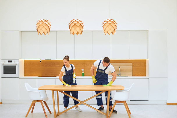 Housekeeping team cleaning kitchen table - Valokuva, kuva