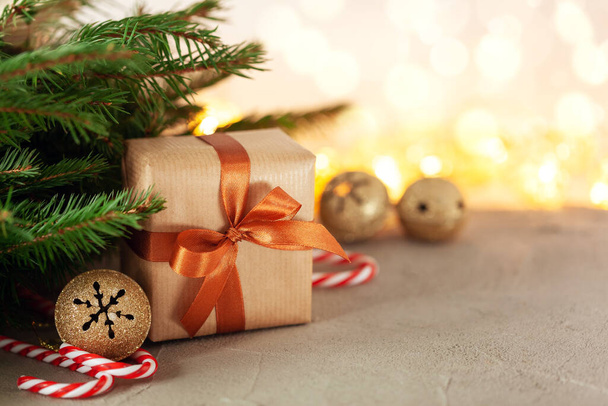 Christmas gift or present box wrapped craft with fir branches and holiday decoration on light bokeh background - Φωτογραφία, εικόνα