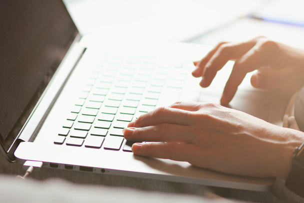 Молодая женщина печатает на клавиатуре ноутбука. Крупным планом. Руки девушки. Работает онлайн. Концепция фрилансера. Магазин на диване. Интернет-магазины
.  - Фото, изображение