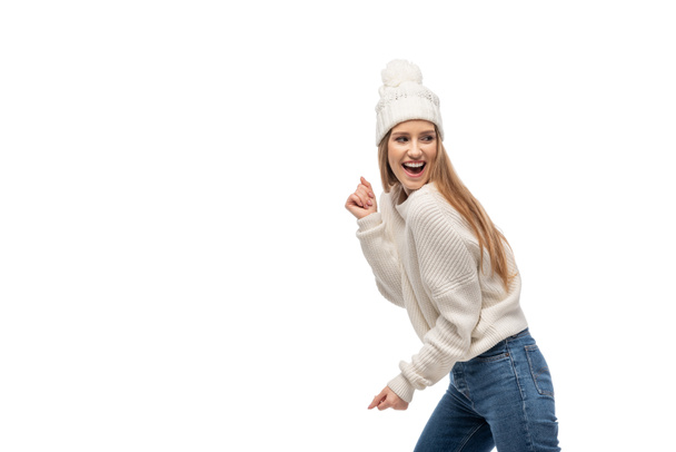 excited woman dancing in white knitted sweater and hat, isolated on white - Valokuva, kuva