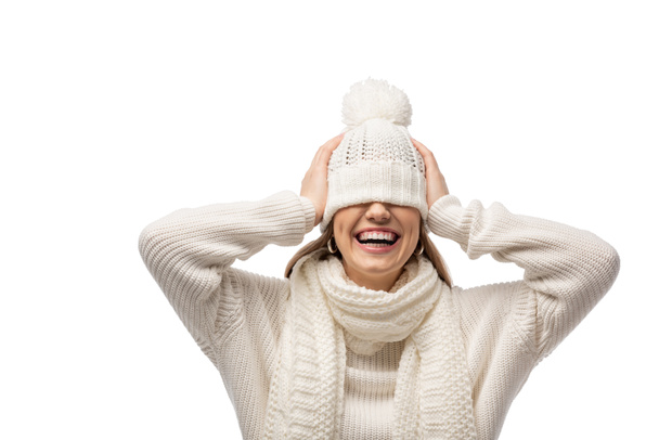 привлекательная смеющаяся женщина согревается в белой вязаной шляпе, изолированной на белом
 - Фото, изображение
