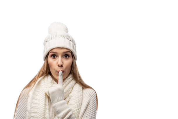 surprised woman in white knitted clothes showing silence symbol, isolated on white  - Photo, Image