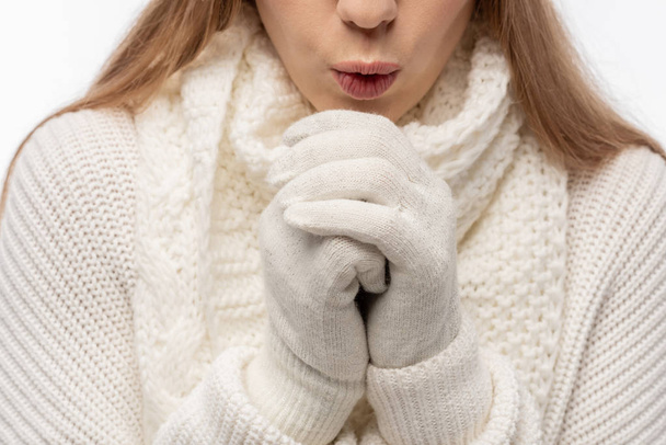 καλλιεργημένη άποψη του κοριτσιού ζέσταμα σε λευκά πλεκτά ρούχα και γάντια, που απομονώνονται σε λευκό - Φωτογραφία, εικόνα