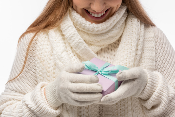 vue recadrée de la femme souriante en écharpe blanche et gants tenant cadeau de Noël, isolé sur blanc
 - Photo, image