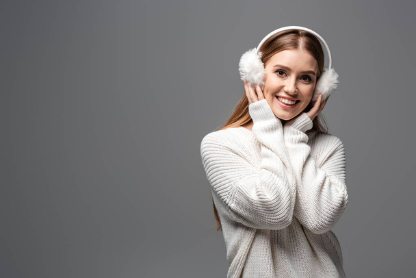 menina alegre atraente posando em suéter branco e auriculares, isolado em cinza
 - Foto, Imagem