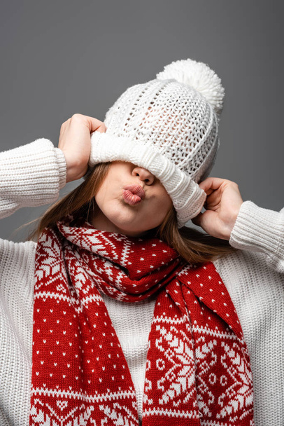 beautiful girl in knitted scarf with hat on eyes, isolated on grey - Photo, Image