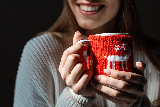 vue recadrée d'une femme souriante tenant une tasse de café de Noël
 - Photo, image
