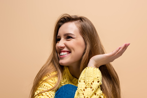 beautiful positive woman in yellow sweater, isolated on beige - Photo, Image