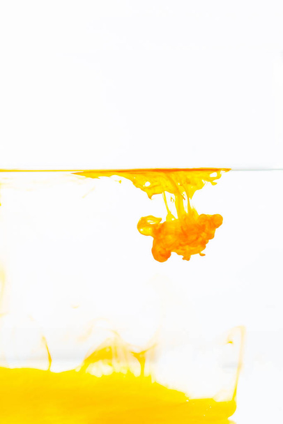 Orange ink drop in water, abstract orange ink in water on white background - 写真・画像