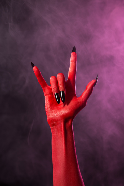 Rock sign, red devil hand with black nails - Φωτογραφία, εικόνα