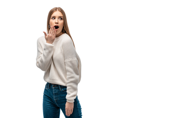 attractive shocked woman in jeans and white sweater, isolated on white - Photo, Image