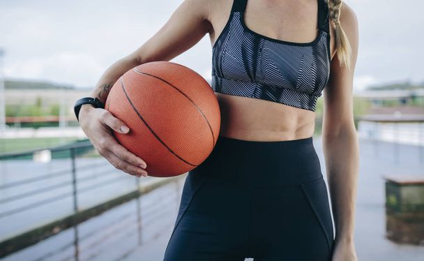 Sportswoman posing with a basketball - Photo, Image