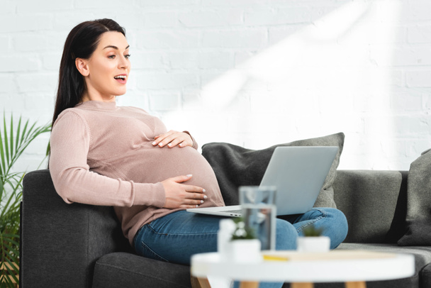 attractive pregnant woman having online consultation with doctor on laptop at home - Фото, зображення