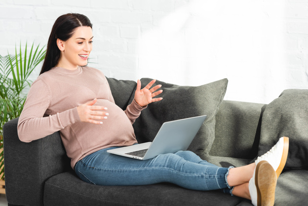 взволнованная беременная женщина, имеющая онлайн консультации с врачом на ноутбуке дома
 - Фото, изображение