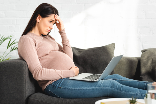 upset pregnant woman having online consultation with doctor on laptop at home - Foto, Imagem
