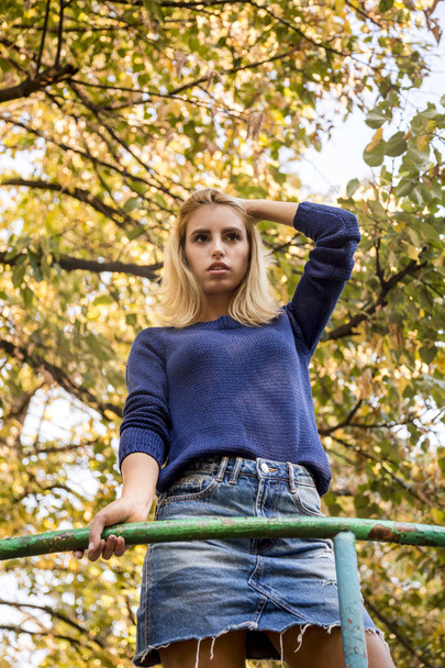 осень. портрет женщины в синем свитере, играющей с листьями
 - Фото, изображение