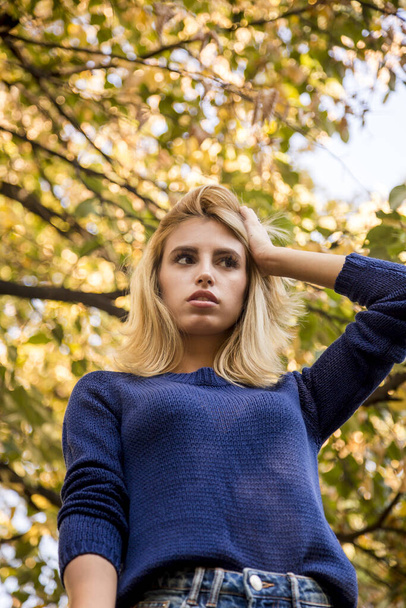 temporada de otoño. retrato de una mujer con suéter azul jugando con hojas
 - Foto, imagen