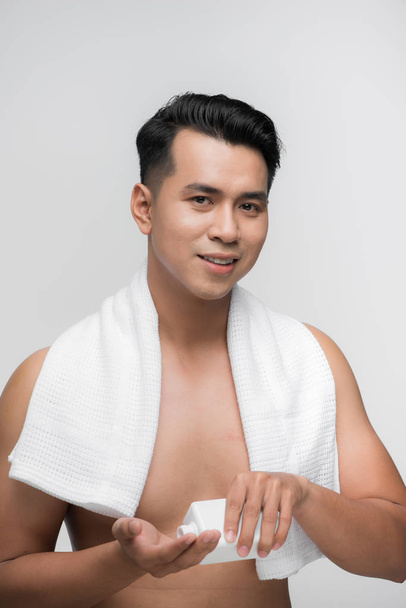asiatische Mann im Badezimmer Anwendung Gesichtslotion - Foto, Bild