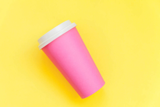 Simply flat lay design pink paper coffee cup isolated on yellow colorful trendy background - Photo, Image