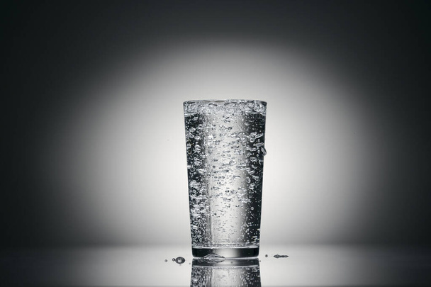 one glass of sparkling water on a dark background - Photo, Image