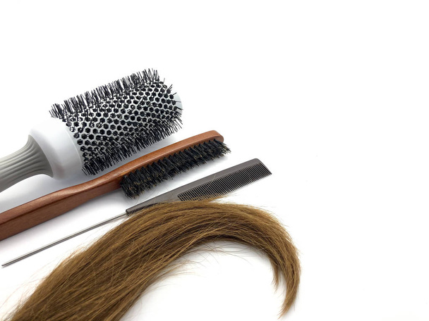 Combs and hair. Composition of professional hairbrushes isolated on white background. Hairdressing tools. Combs. Composition for a beauty salon. Natural brown hair. - Photo, image