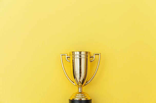 Winner or champion gold trophy cup isolated on yellow colorful background - Photo, Image