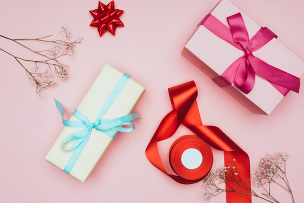 top view of christmas gift boxes with flowers, ribbons and bows, isolated on pink - Foto, immagini