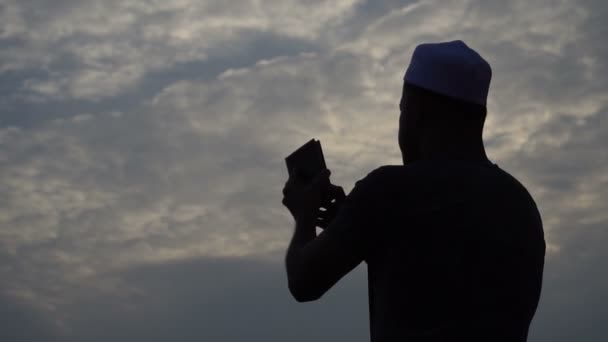 Jonge Aziatische moslim man biddend bij zonsondergang - Video