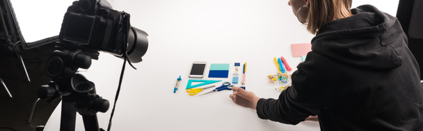 cropped view of photographer making flat lay with office supplies for commercial photo shooting on white, panoramic shot - 写真・画像