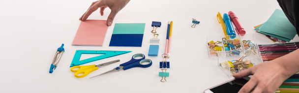 cropped view of professional photographer making flat lay with office supplies for commercial photo shooting on smartphone, panoramic shot - Fotoğraf, Görsel