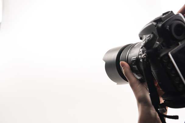 обрезанный вид фотографа, работающего с цифровой камерой, изолированной на белом
 - Фото, изображение