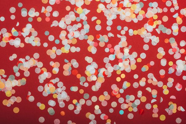 top view of christmas confetti on red - Foto, afbeelding