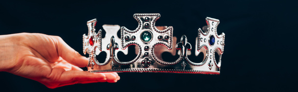 cropped view of woman holding silver crown with gemstones, isolated on black, panoramic shot - Photo, Image